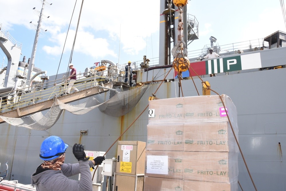 Husbanding contractors operate lifting cranes to deliver cargo aboard USNS Supply March 4, 2022, at August Bay Pier, Sicily. After it was loaded with cargo, provisions and mail, the ship departed the pier to meet the HSTCSG for a replenishment-at-sea. (U.S. Navy photo by Joe Yanik)
